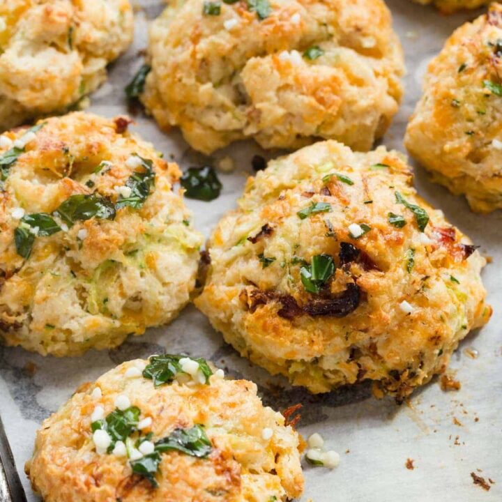 Drop Biscuits with Cheese, Zucchini, & Tomato on white parchment paper.