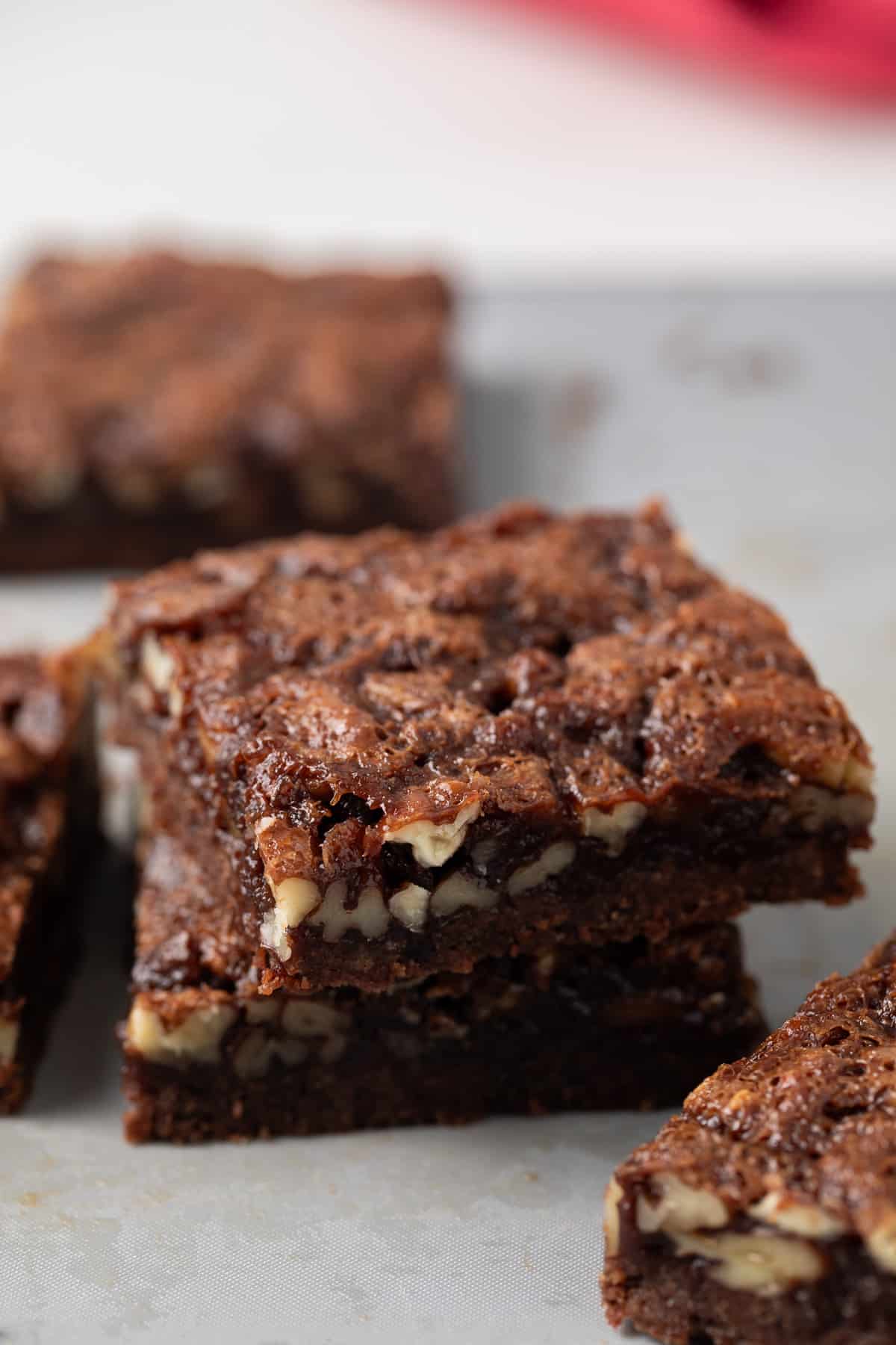 Two chocolate bourbon pecan bars stacked.