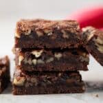 Three chocolate bourbon pecan bars stacked.