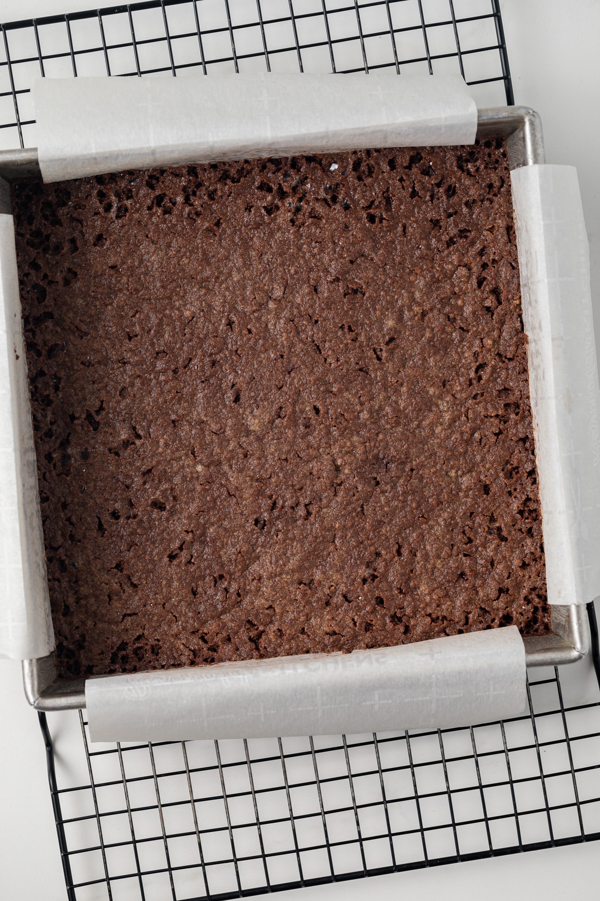 Chocolate shortbread crust baked in a square pan.