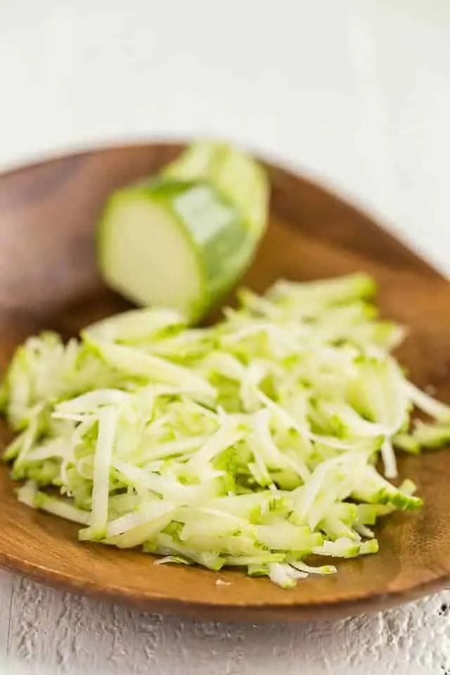 Shredded zucchini on bamboo plate.