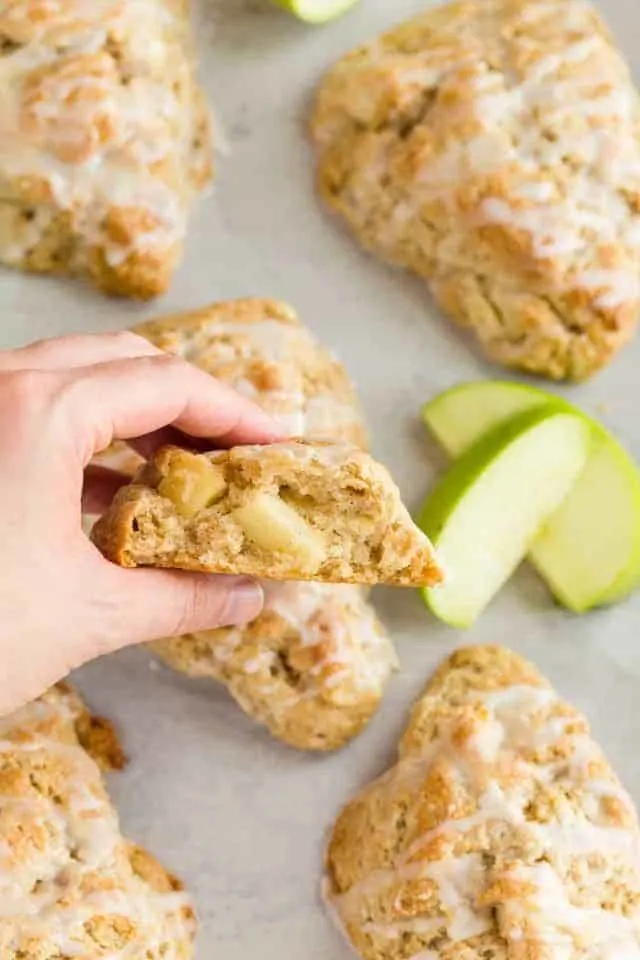 A hand holding a scone that's been broken open so the flaky center is visible.