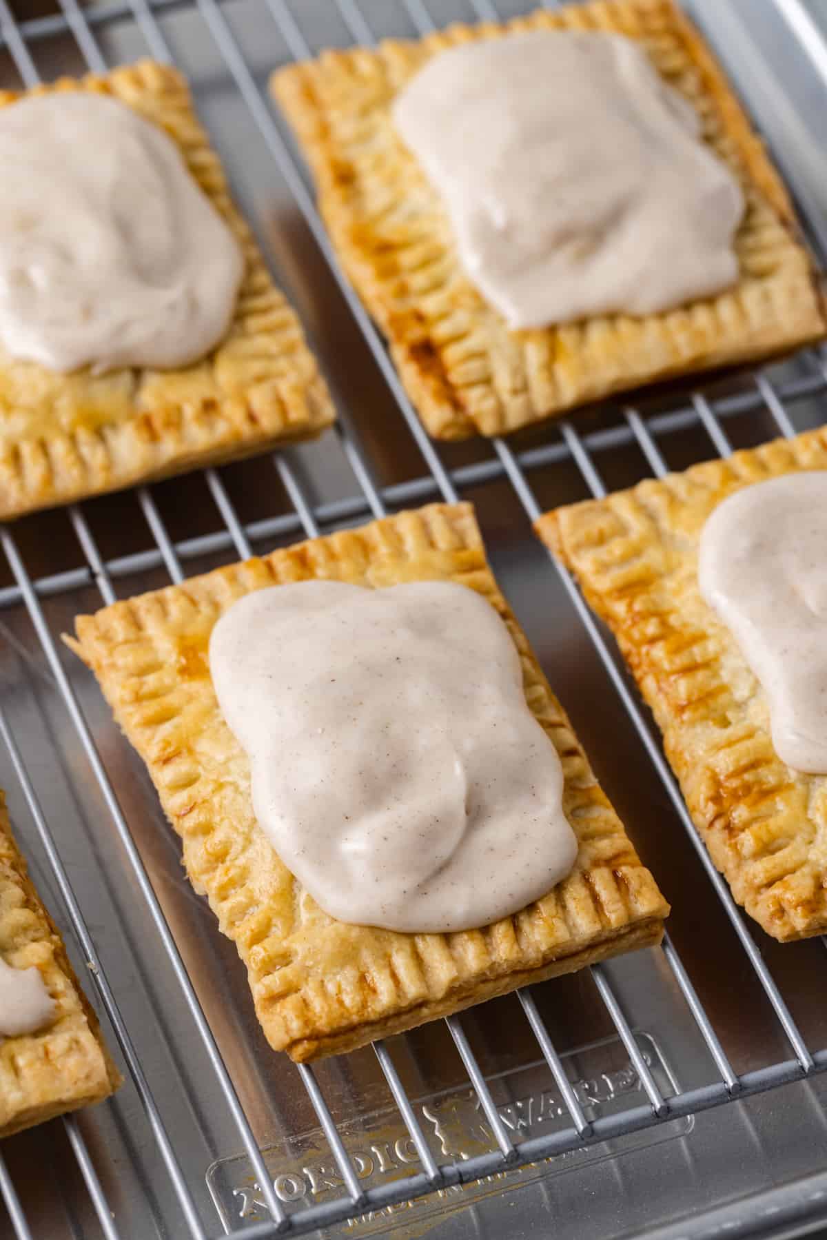 Homemade pop tarts on a cooling rack topped with cinnamon frosting