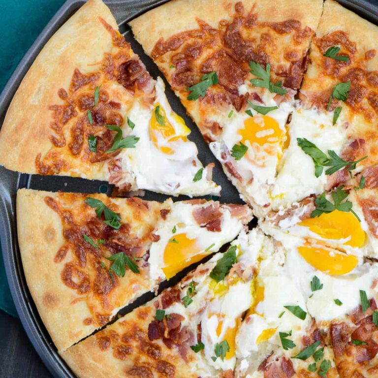 overhead view of bacon egg breakfast pizza sliced