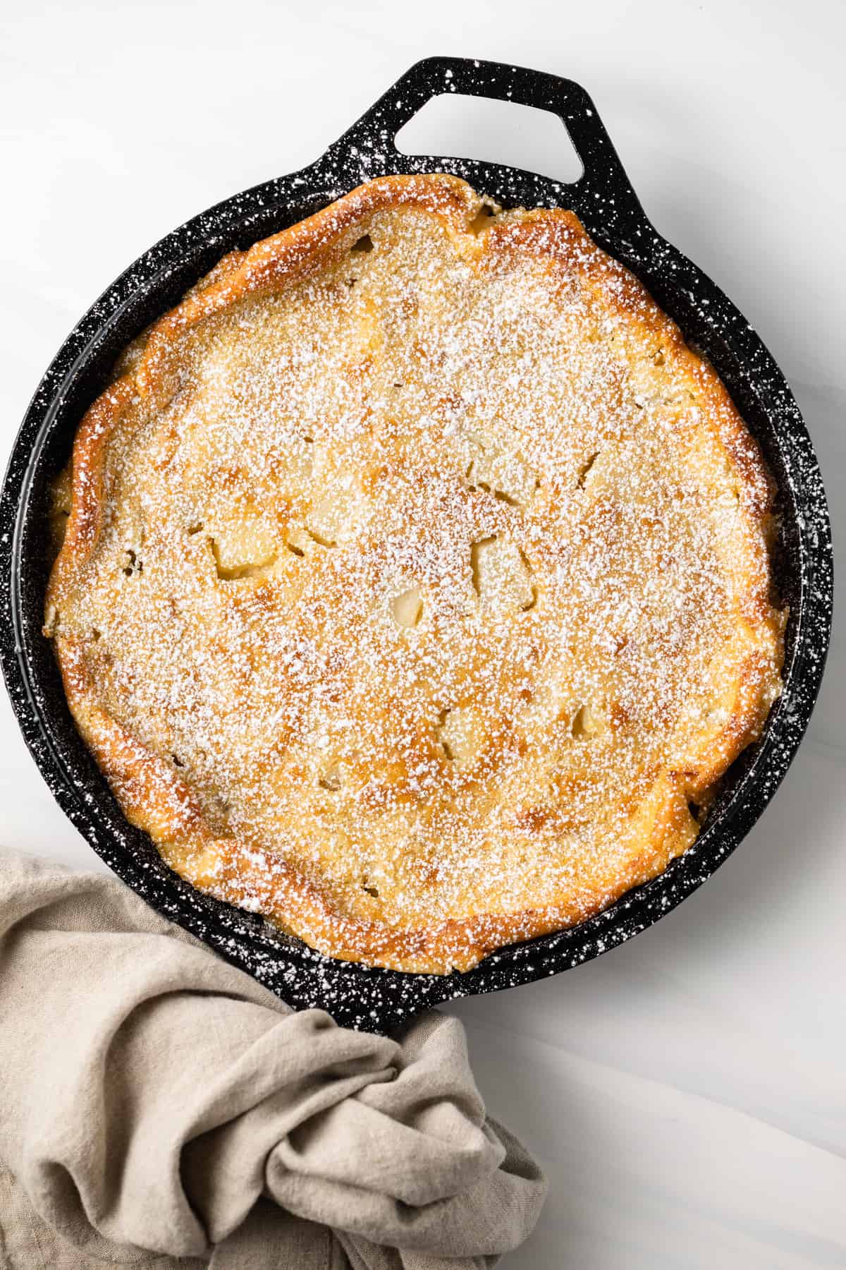 Overhead view of maple pear clafoutis in a cast iron skillet.