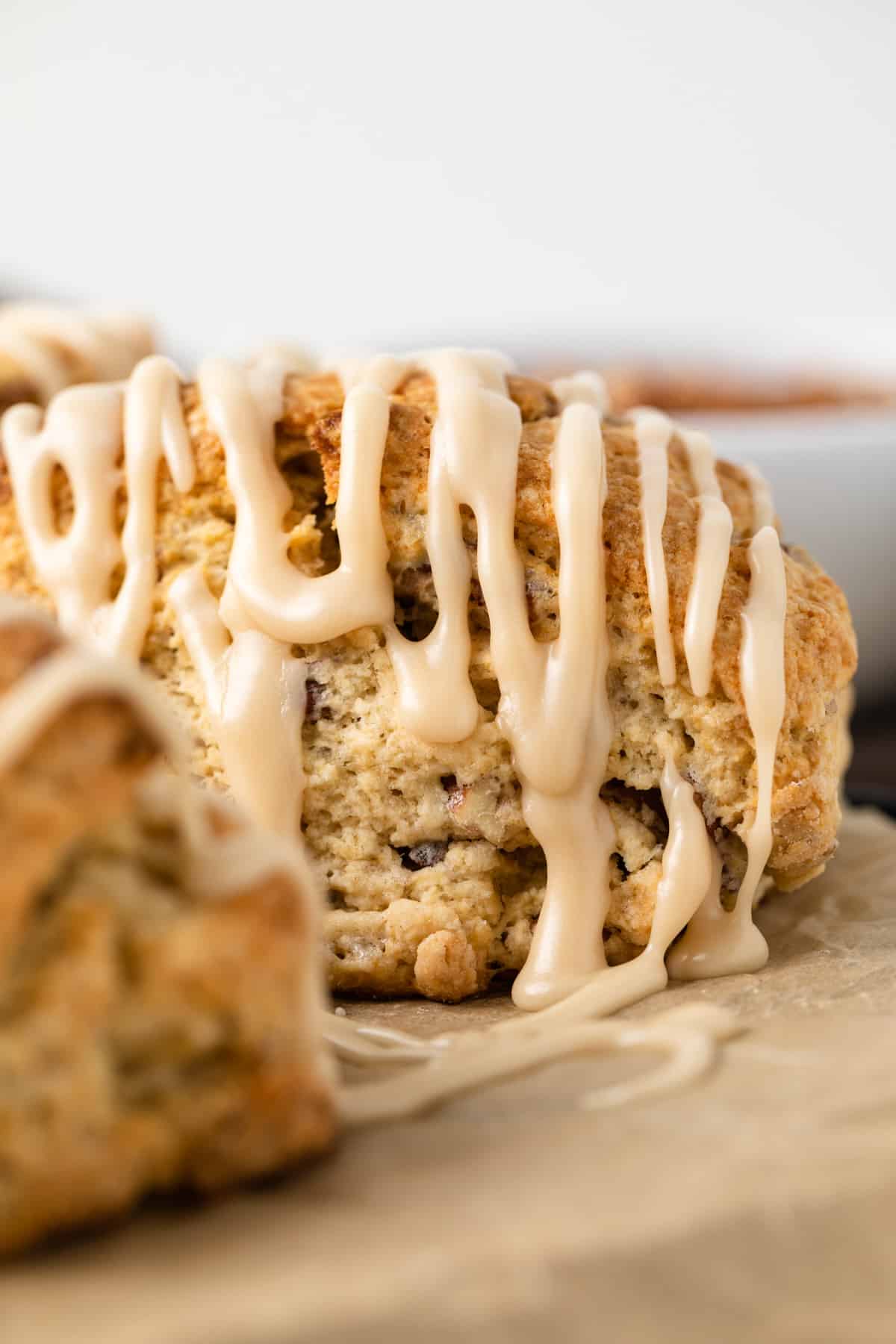 Side view of maple pecan scones drizzled with maple syrup