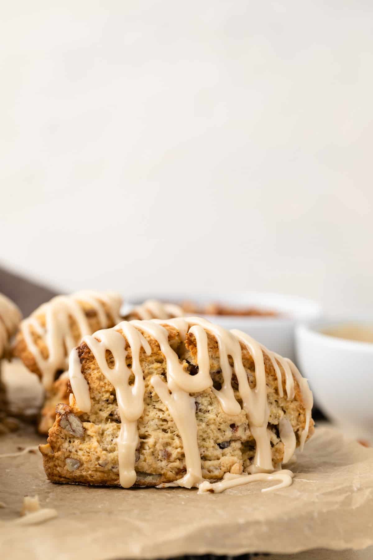 Side view of maple pecan scones drizzled with maple syrup