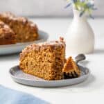 Slice of sweet potato coffee cake on plate with fork taking a bite out.
