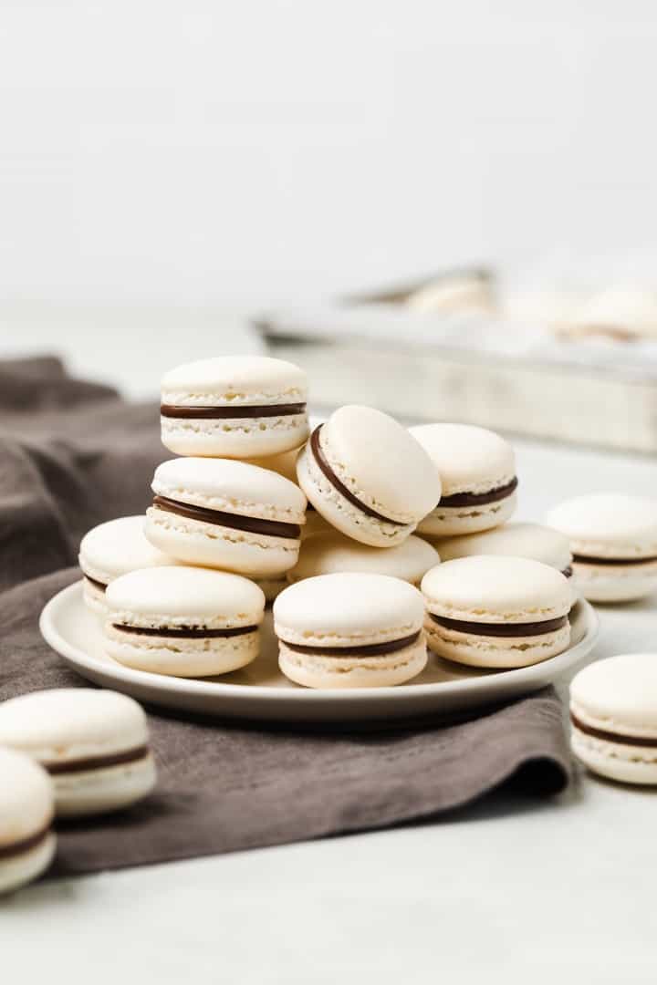 gorgeous macarons with chocolate filling on a white plate