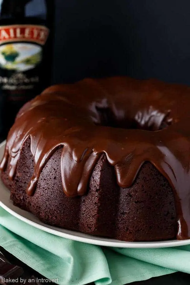 Side view of Irish chocolate coffee bundt cake on a cream plate set over a green napkin.