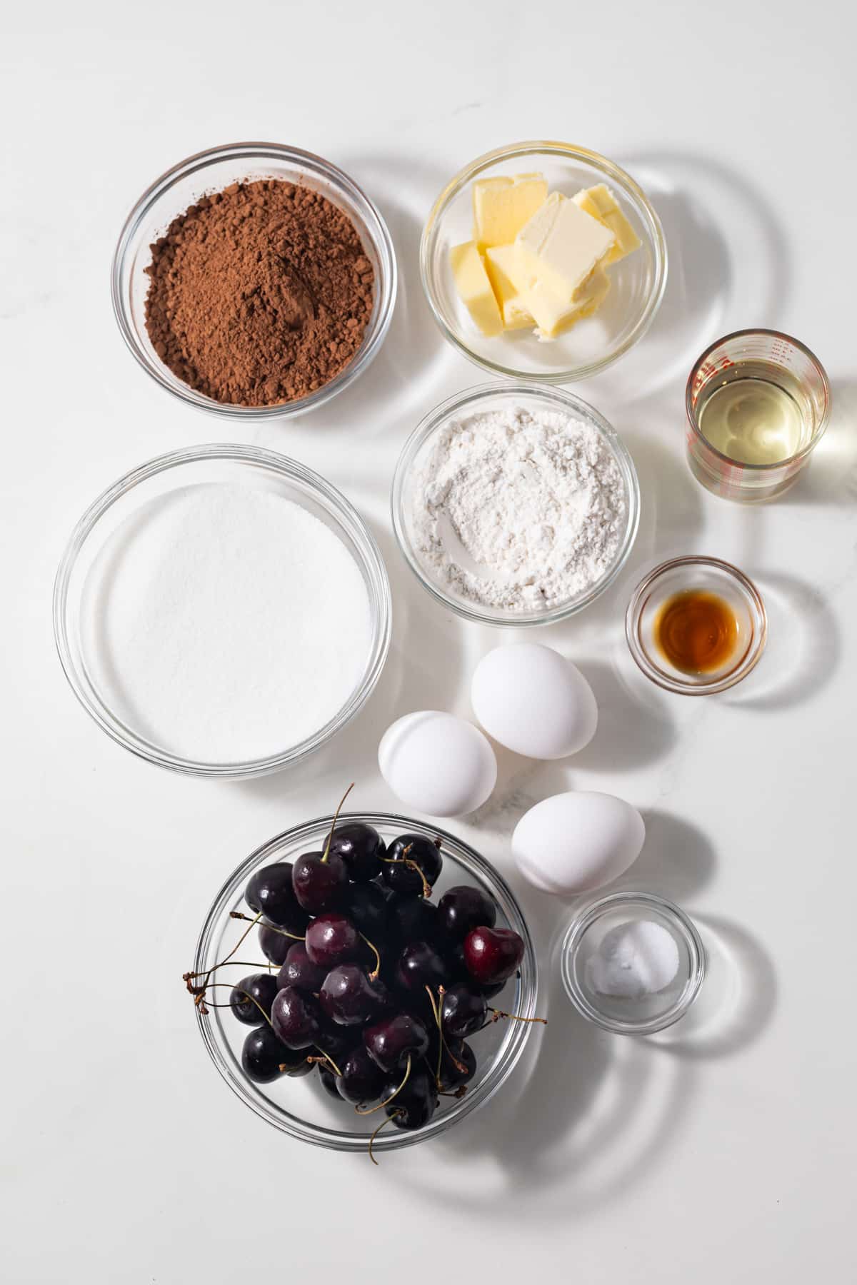 Ingredients for brownies with cherries in glass bowls.