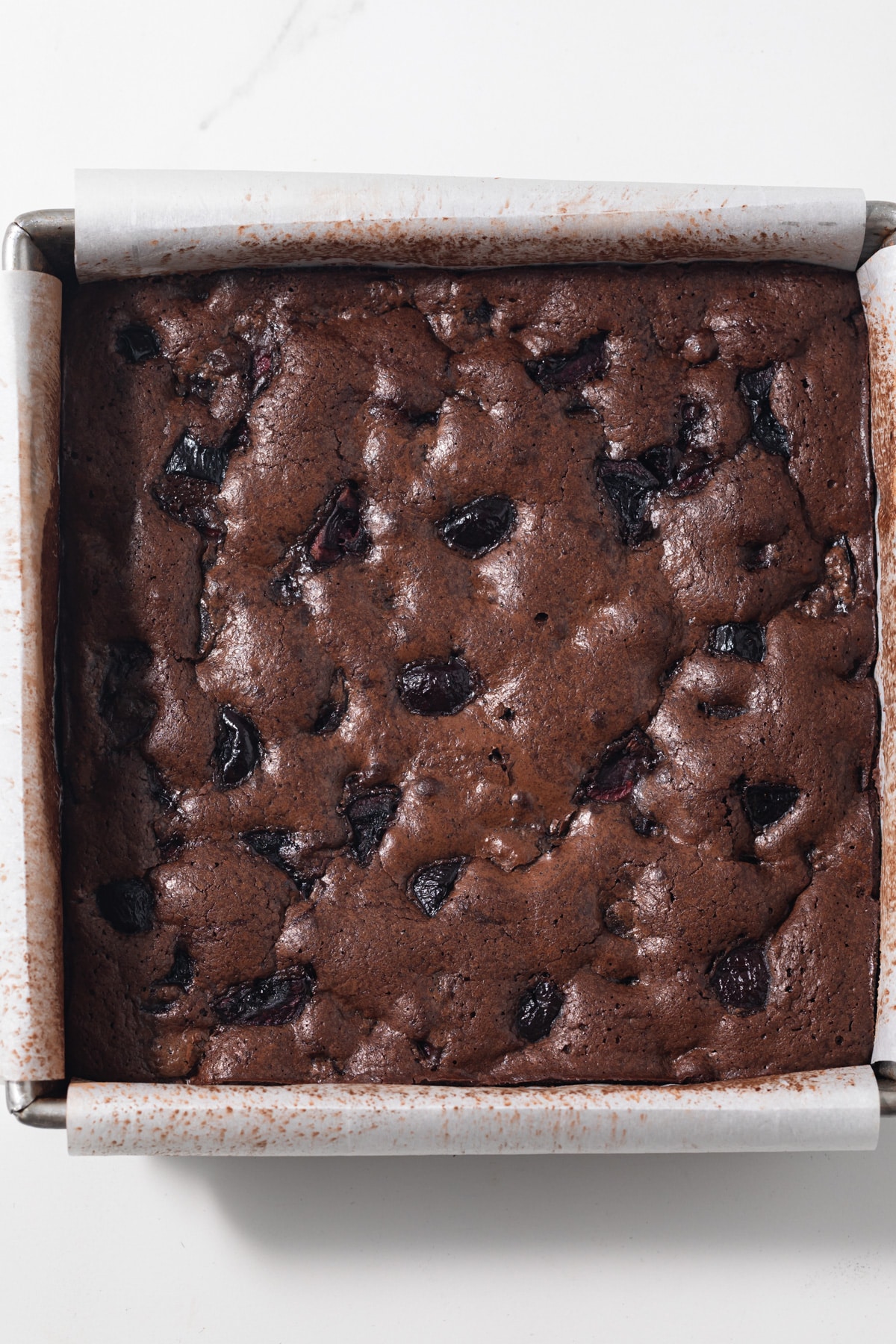 Cherry chocolate brownies in a square baking pan.