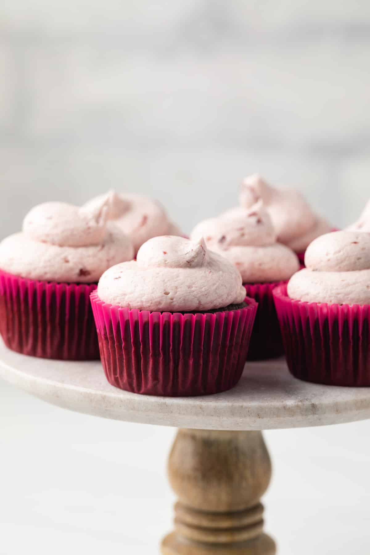 Chocolate cherry cupcakes on cake stand.