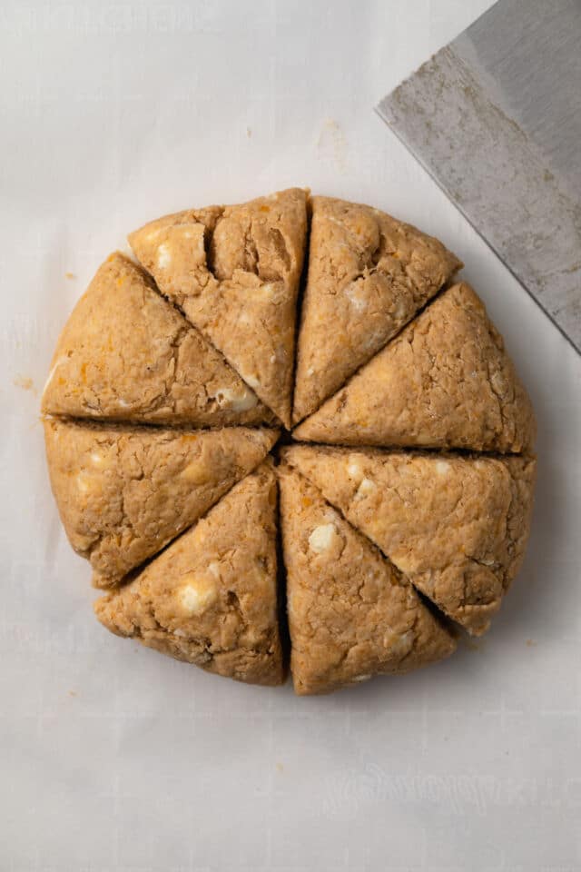 Unbaked scone dough cut into triangles.