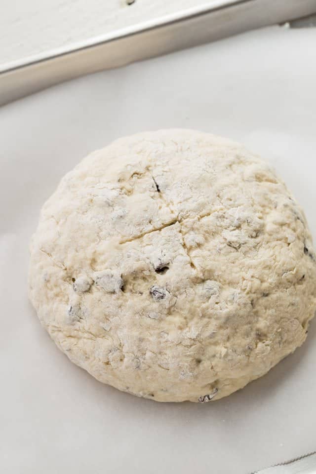 Irish soda bread dough shaped in a ball on a baking sheet.