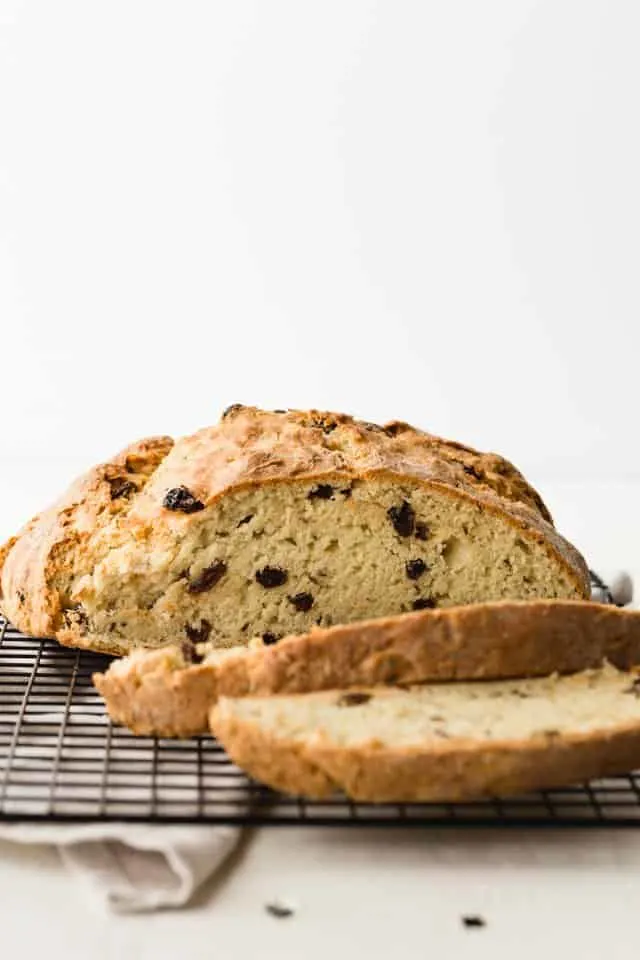 Irish soda bread on a wire rack with two slices taken out.