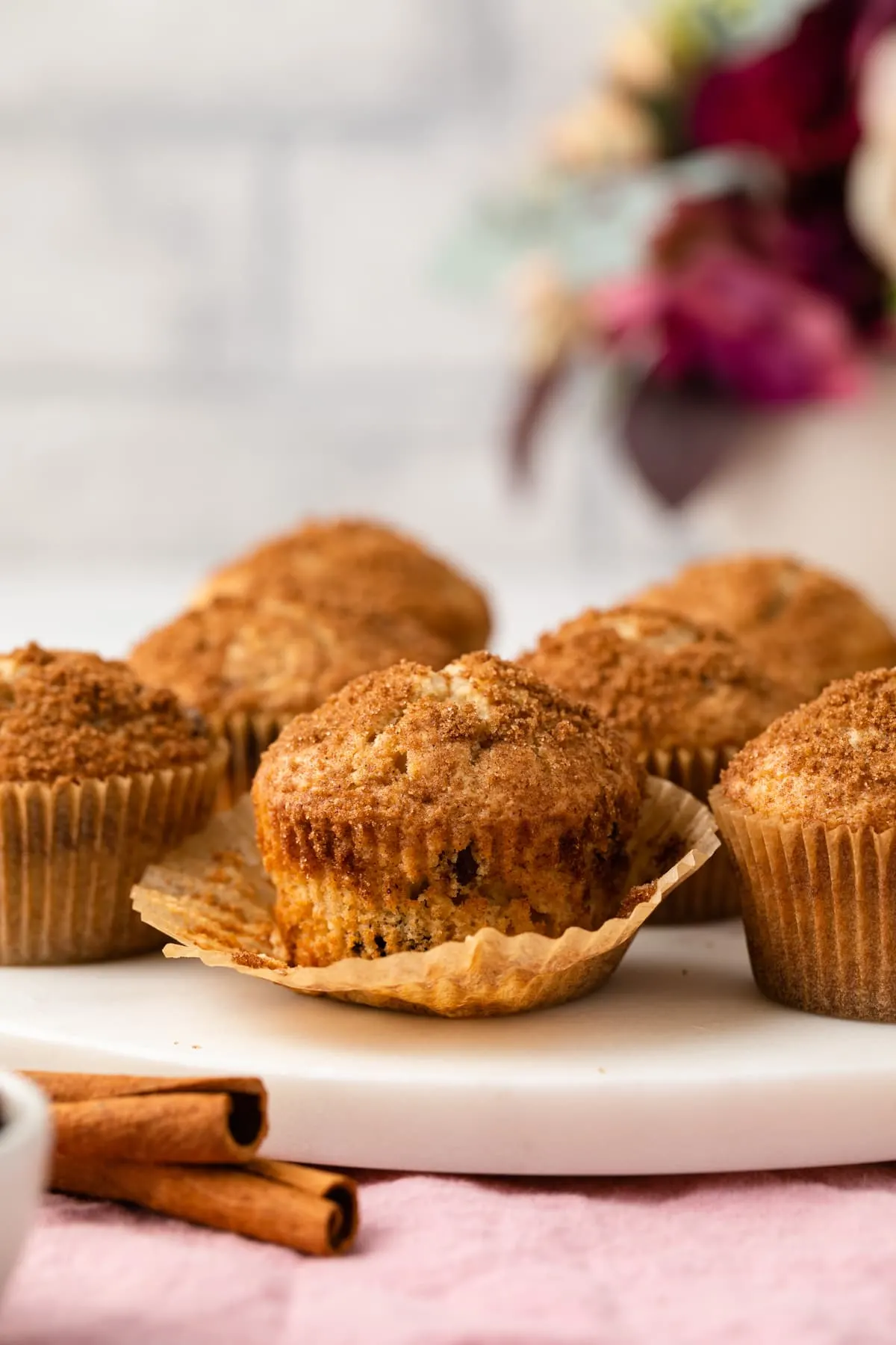 Cinnamon raisin muffin with paper pulled away.