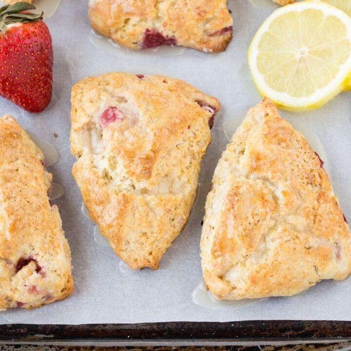 Overhead view of Lemon Cream Cheese Scones filled with fresh strawberries on a baking sheet.