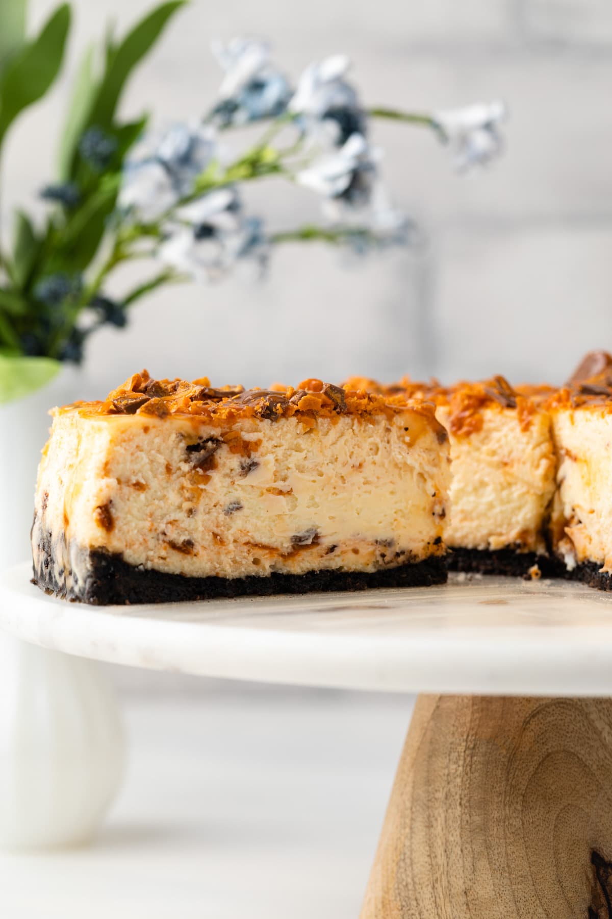 Slice of butterfinger cheesecake on cake plate.