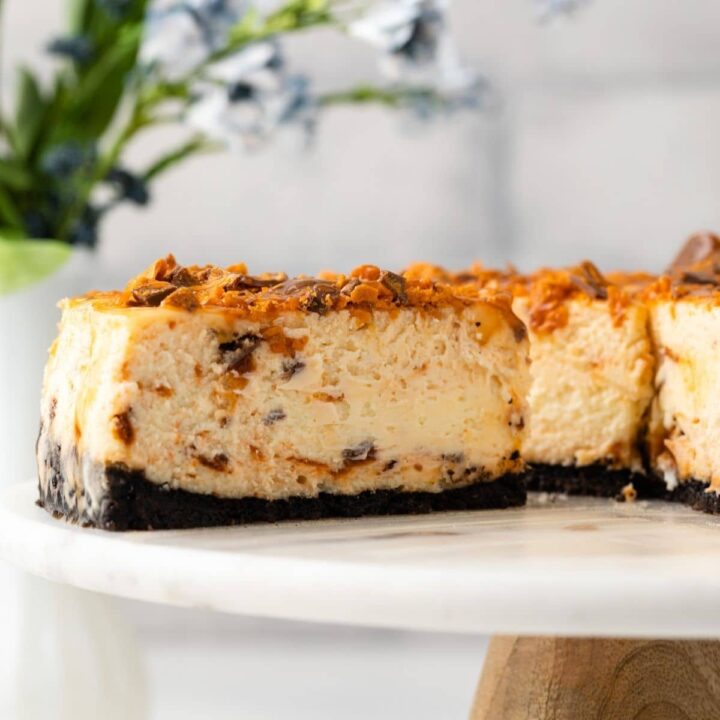 Slice of butterfinger cheesecake on cake plate.