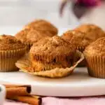 Cinnamon raisin muffin with paper pulled away.