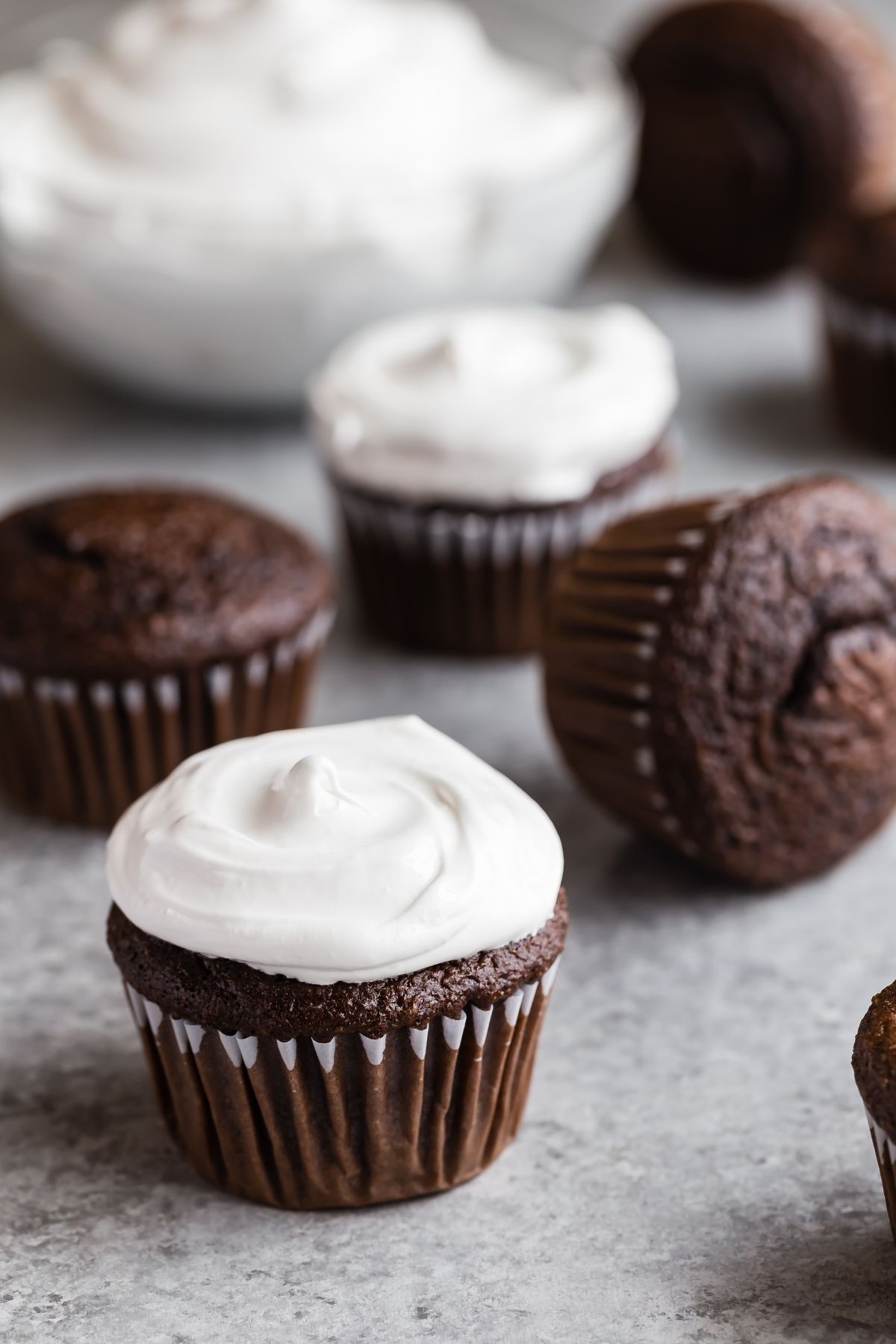 Side view of Old-fashioned 7 Minute Frosting swirled on top of chocolate cupcakes.