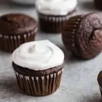 Side view of Old-fashioned 7 Minute Frosting swirled on top of chocolate cupcakes.