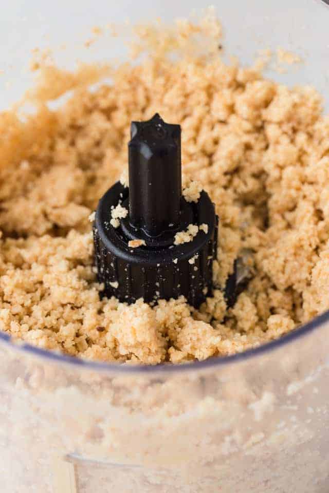 Ground hazelnuts in the bowl of a food processor.