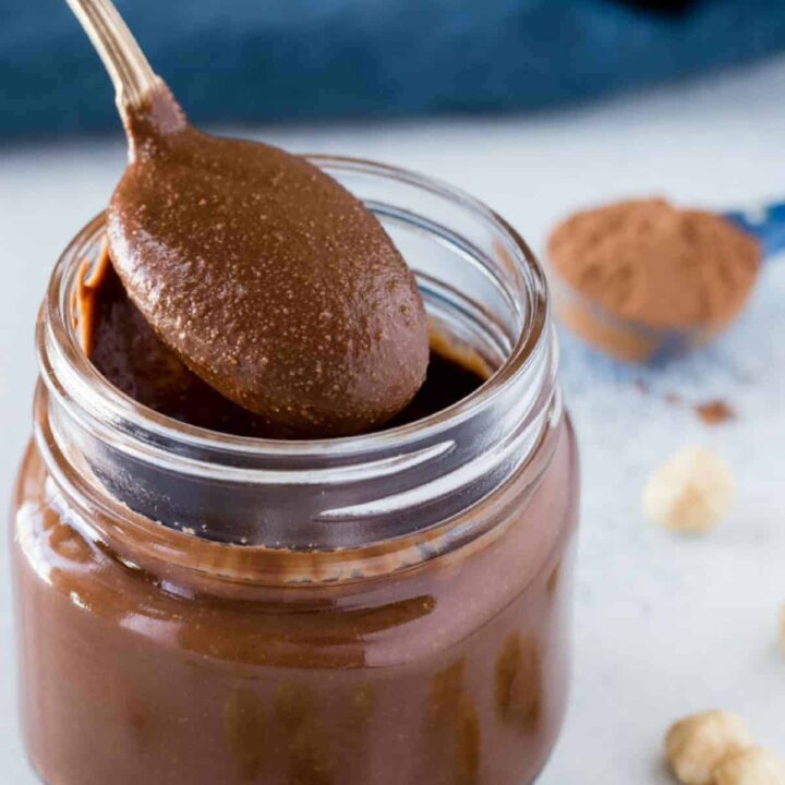 A jar of homemade nutella with a spoon getting some out.