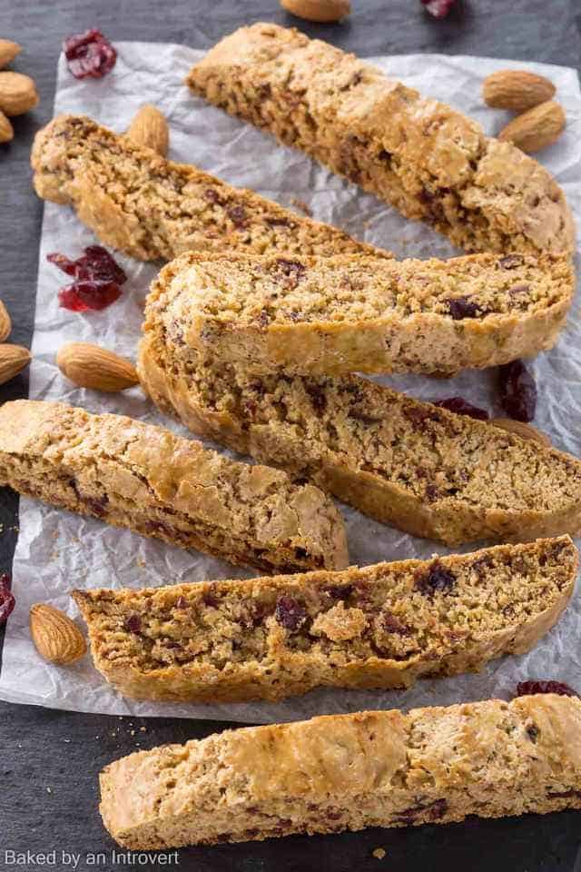 high angled view of cherry almond biscotti on a slate platter with white parchment paper