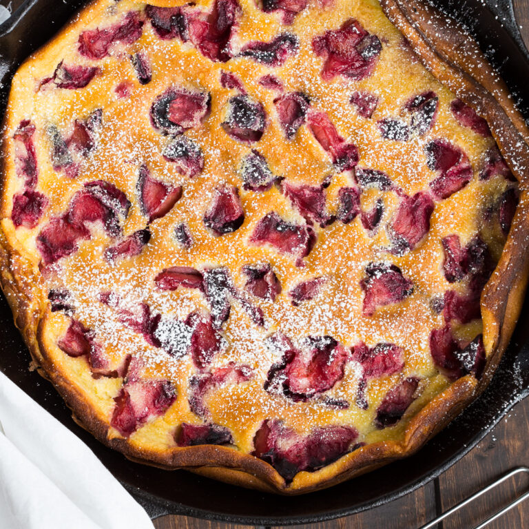 Overhead view of Roasted Plum Clafoutis in a cast iron pan.