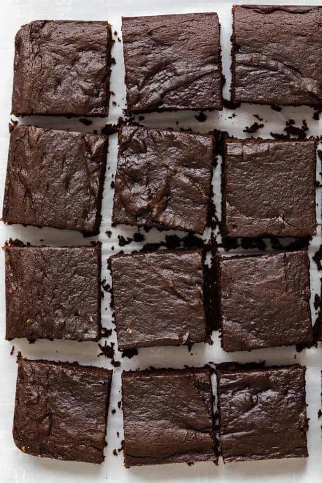 Vegan brownies on a white board, loaded with chocolate