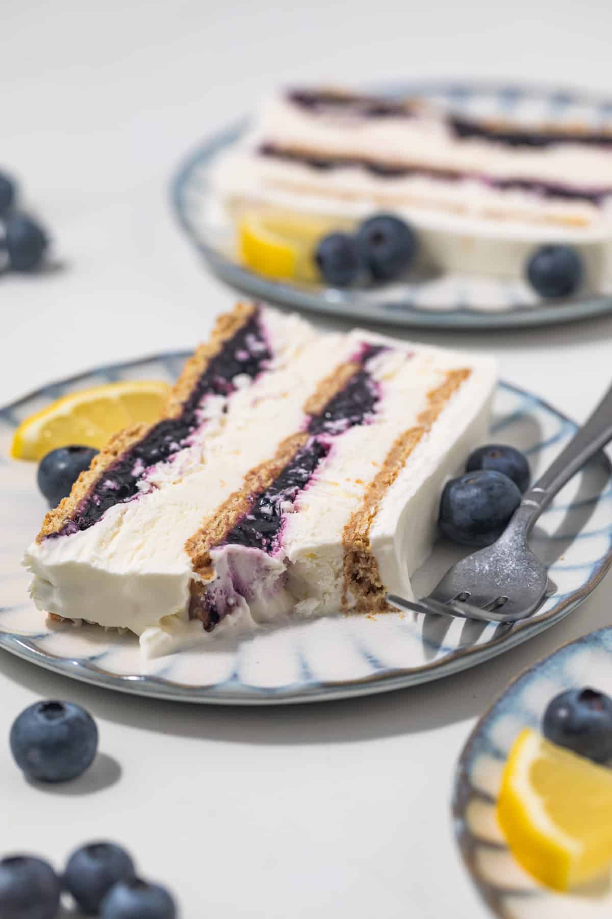 Slice of blueberry lemon icebox cake with a bite taken out.