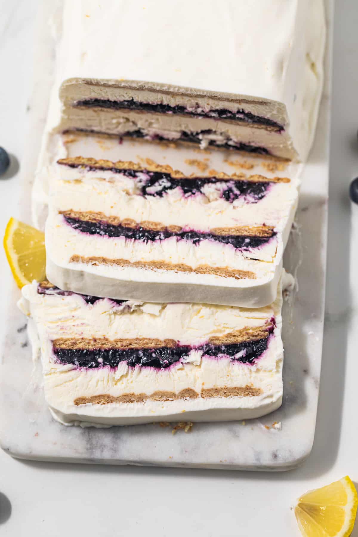 Blueberry lemon icebox cake with slices cut out.