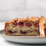 Raspberry coffee cake with a slice taken out so the inside is visible.
