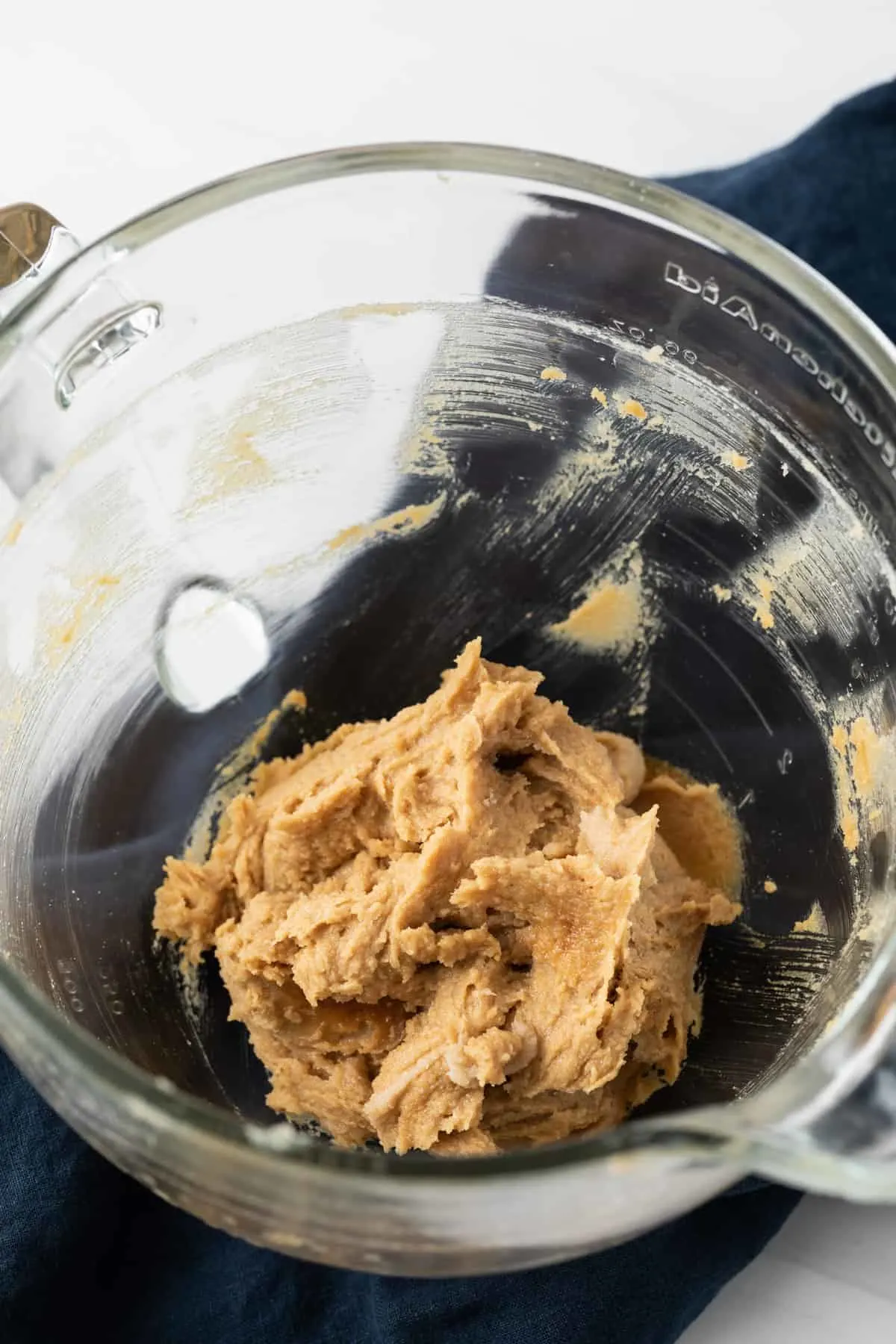 process shots showing creamed butter and sugar in glass bowl next to pumpkin base for cookies in glass bowl