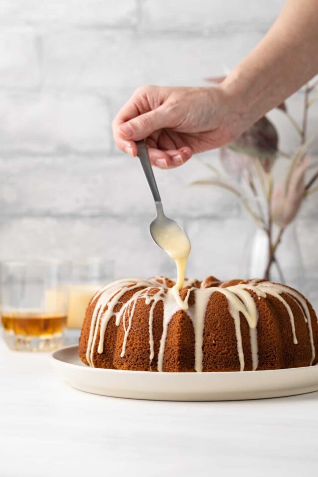A spoon dripping rum glaze over a bundt cake