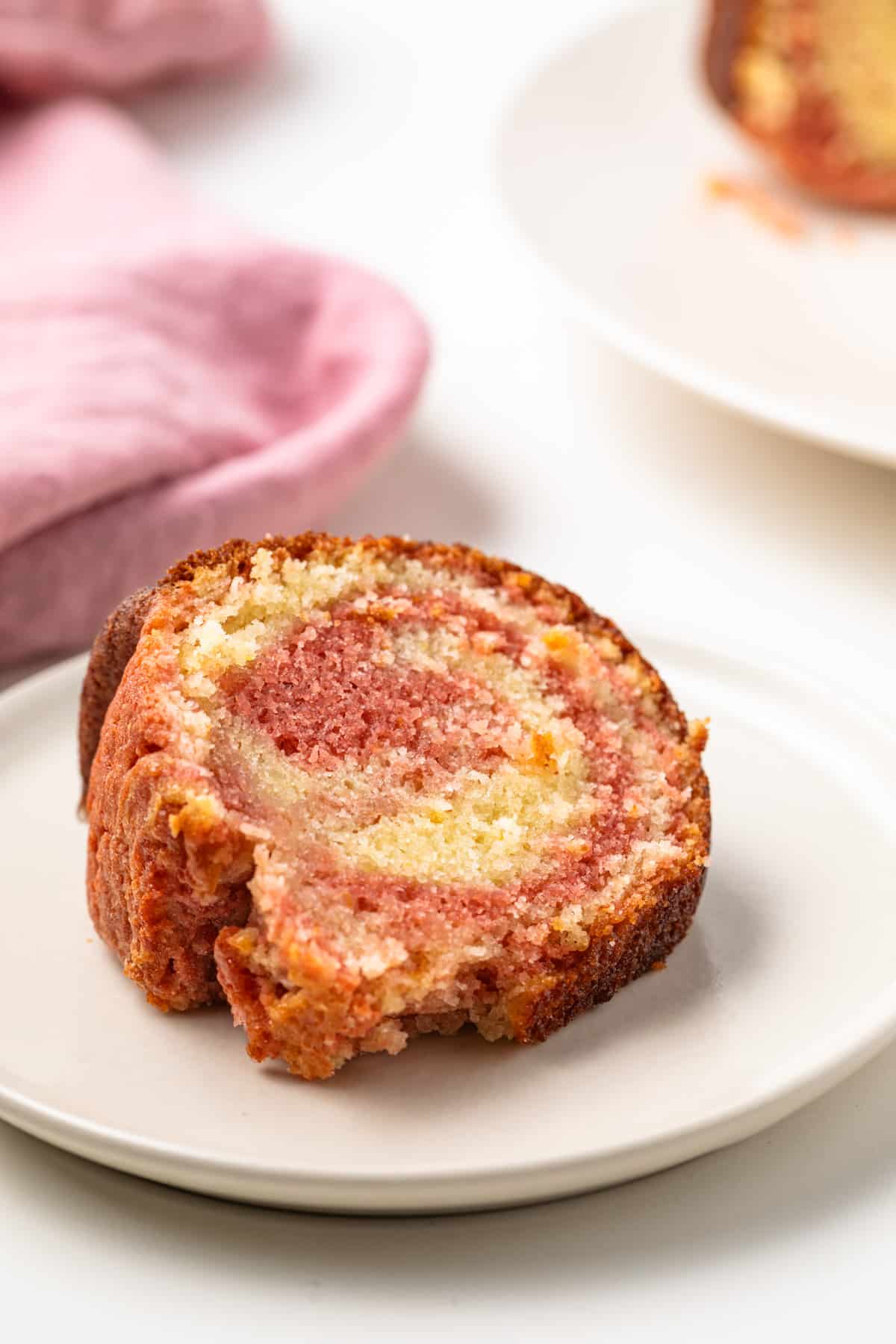 Slice of tequila sunrise cake on a plate.