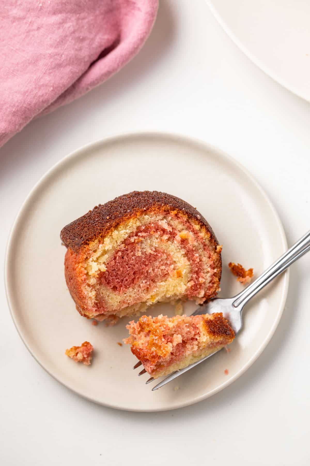 A fork taking a bit out of tequila sunrise cake slice.