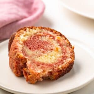 Slice of tequila sunrise cake on a plate.