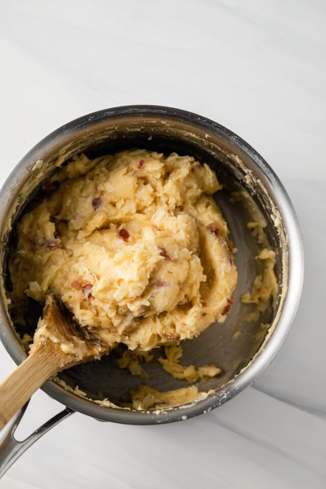 Bacon garlic gougeres dough in a pot being stirred