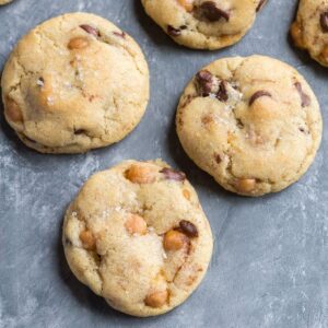 Overhead view of Soft and chewy Chocolate Chip Salted Caramel Cookies on a grayish blue background.