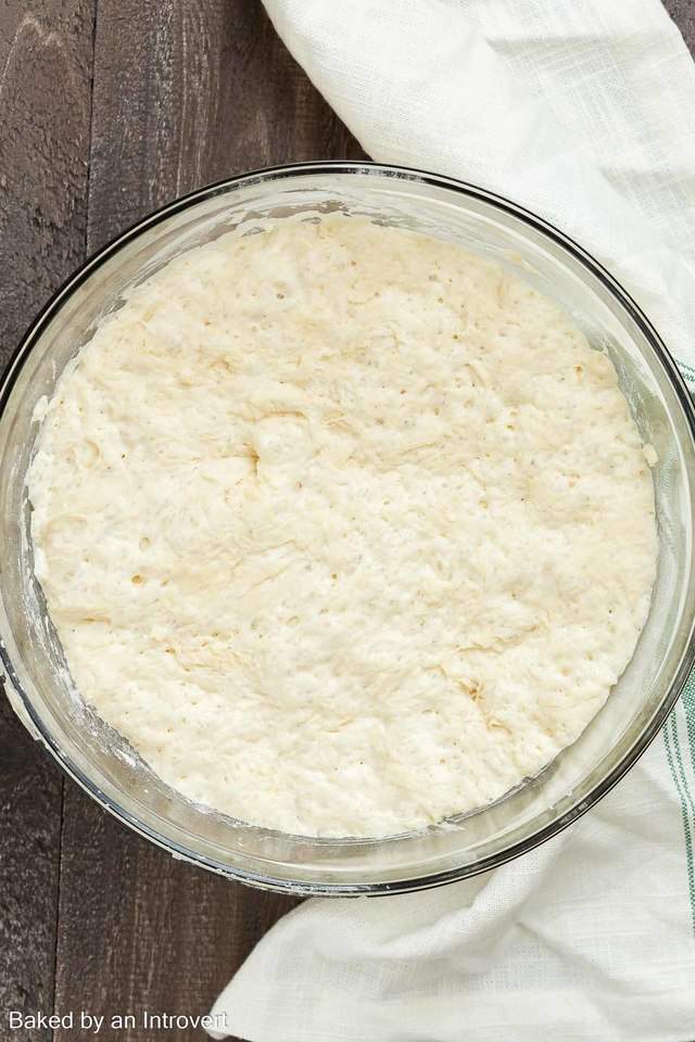 Slow cooker bread dough in a glass bowl.