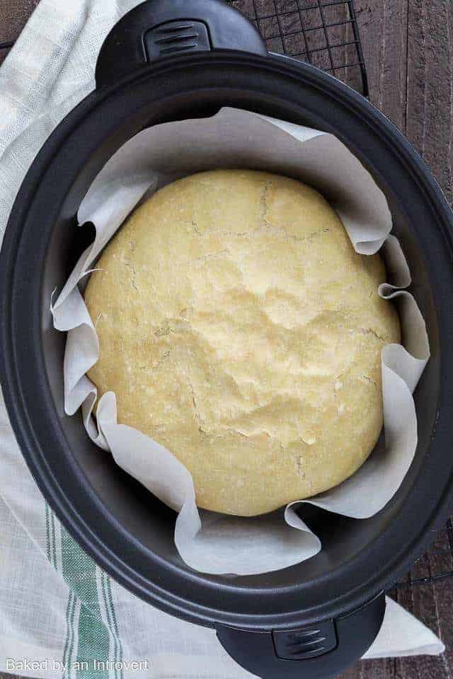 Homemade Slow Cooker Bread in a slow cooker lined with white parchment paper.
