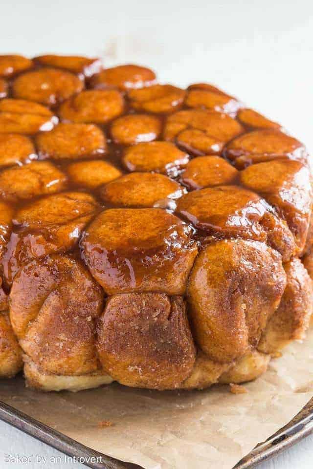 Slow Cooker Monkey Bread on a baking sheet lined with brown parchment paper.