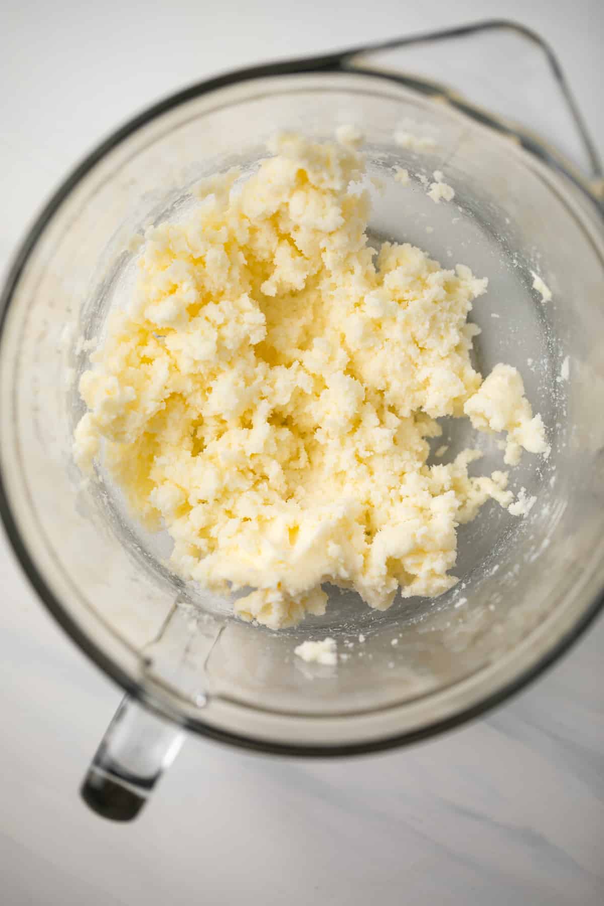 Butter and sugar creamed in glass bowl.