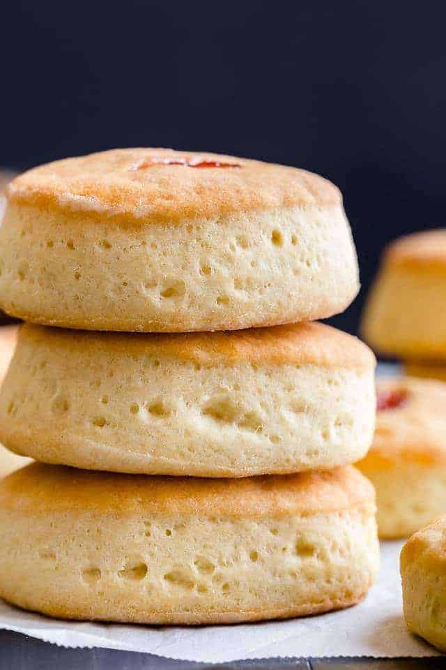 side view of three buttery jam biscuits stacked on one another