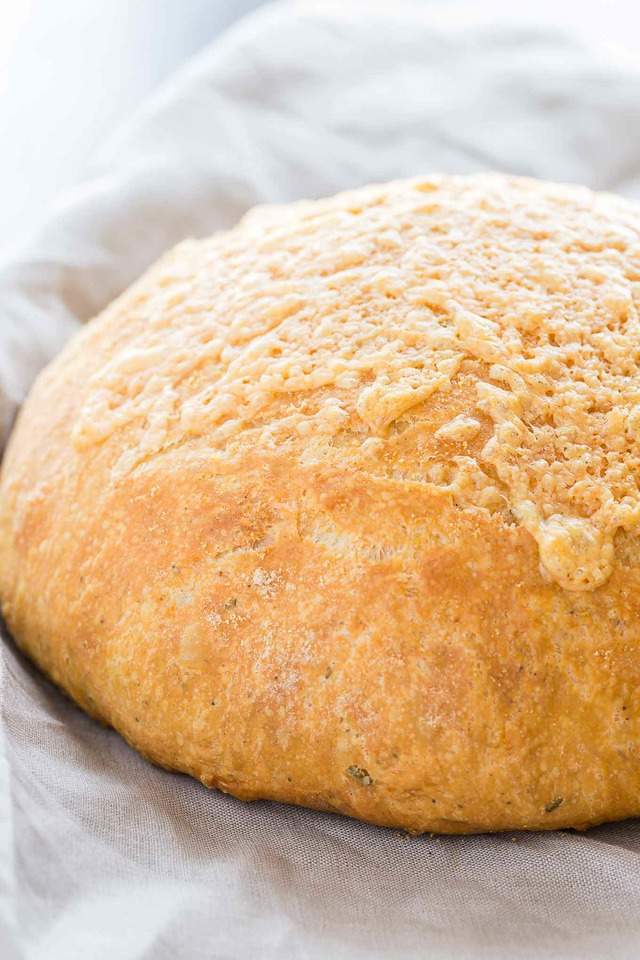 Round loaf of Rosemary Cheese Bread on a gray napkin.