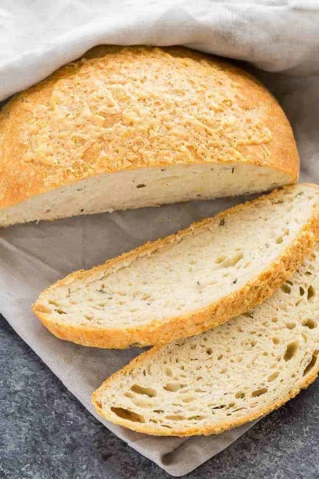 A loaf of Rosemary Cheese Bread with two slices cut out.