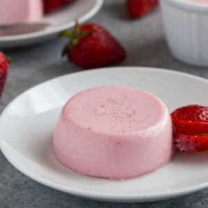 Strawberry panna cotta on a white plate.